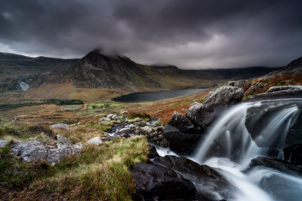 Afon Lloer with Tryfan and Llyn Ogwen in Snowdonia, North Wales on a moody evening.