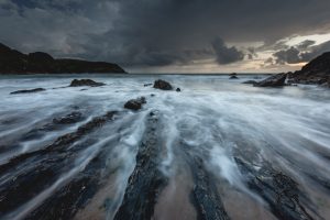 A long exposure of a moody and dramatic sunset at Hope Cove in South Devon